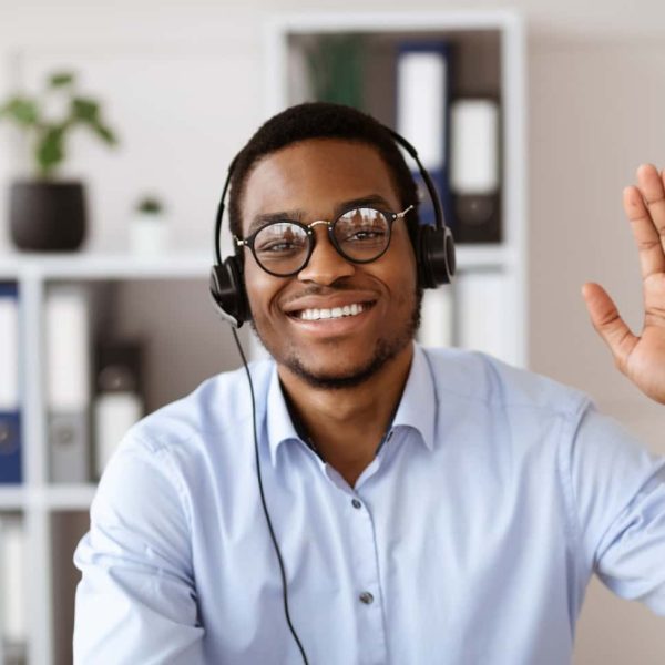 happy-black-consultant-with-headset-waving-at-came-2022-12-16-08-19-05-utc-min.jpg